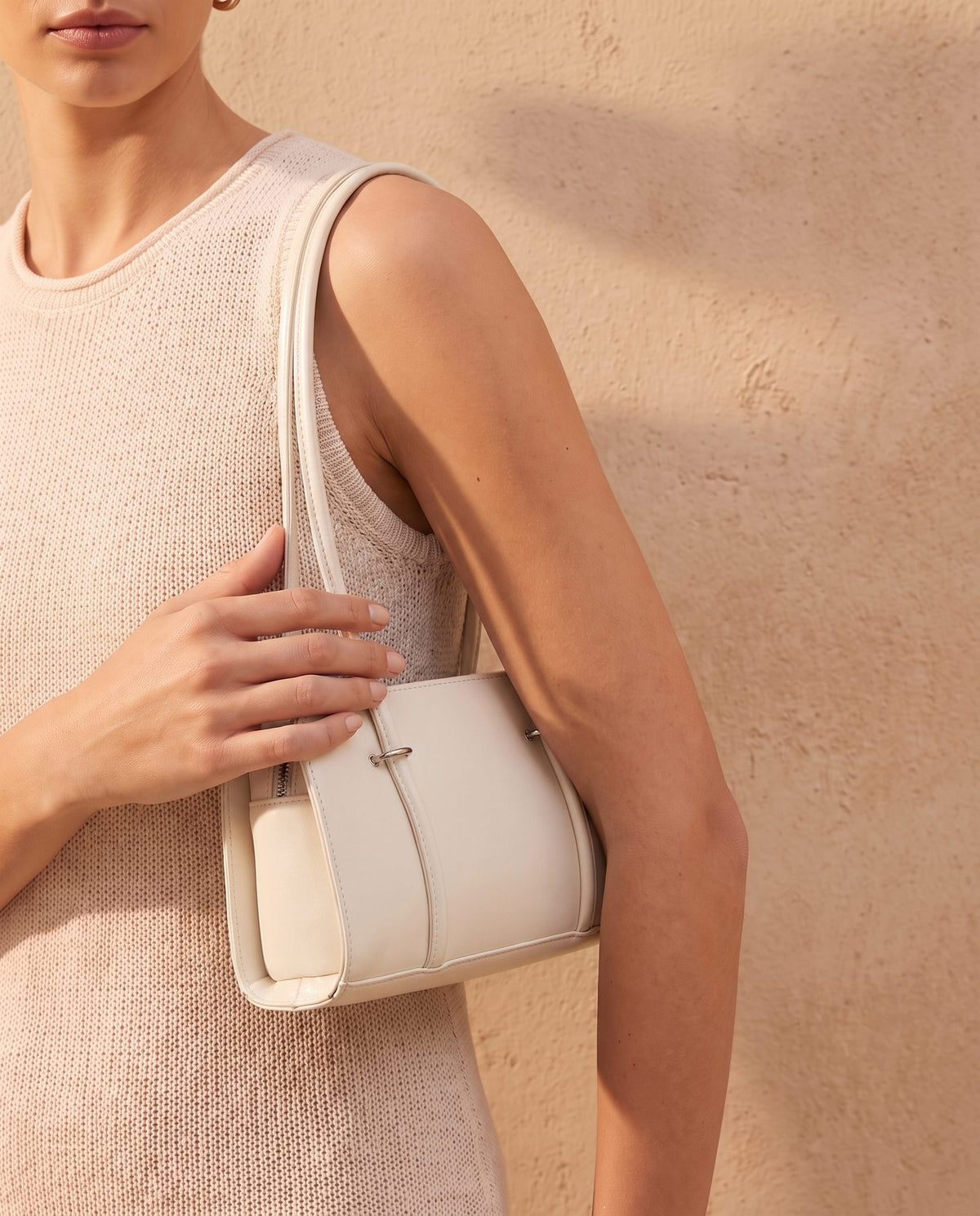 Model wearing the Badr cream baguette bag on her shoulder, compact 28 cm women's bag